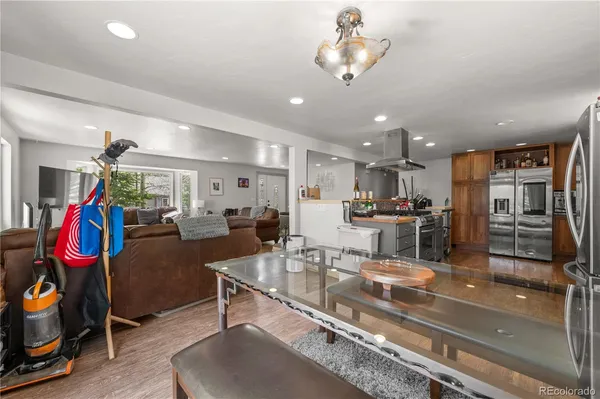 a large kitchen with stainless steel appliances kitchen island granite countertop a large stove a sink dishwasher and white cabinets with wooden floor