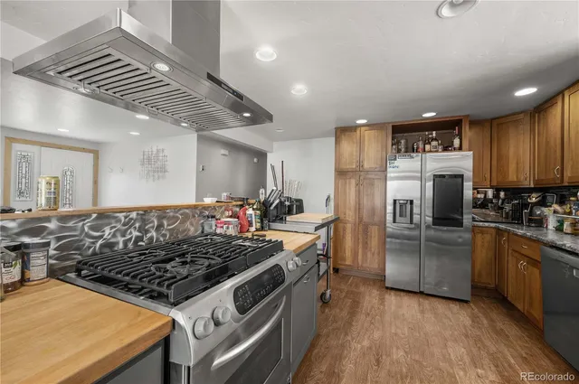 a kitchen with stainless steel appliances granite countertop a sink stove and refrigerator