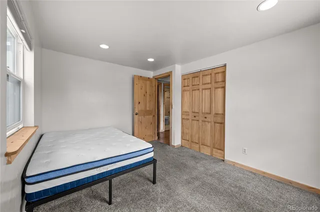 a bed sitting in a bedroom next to a window