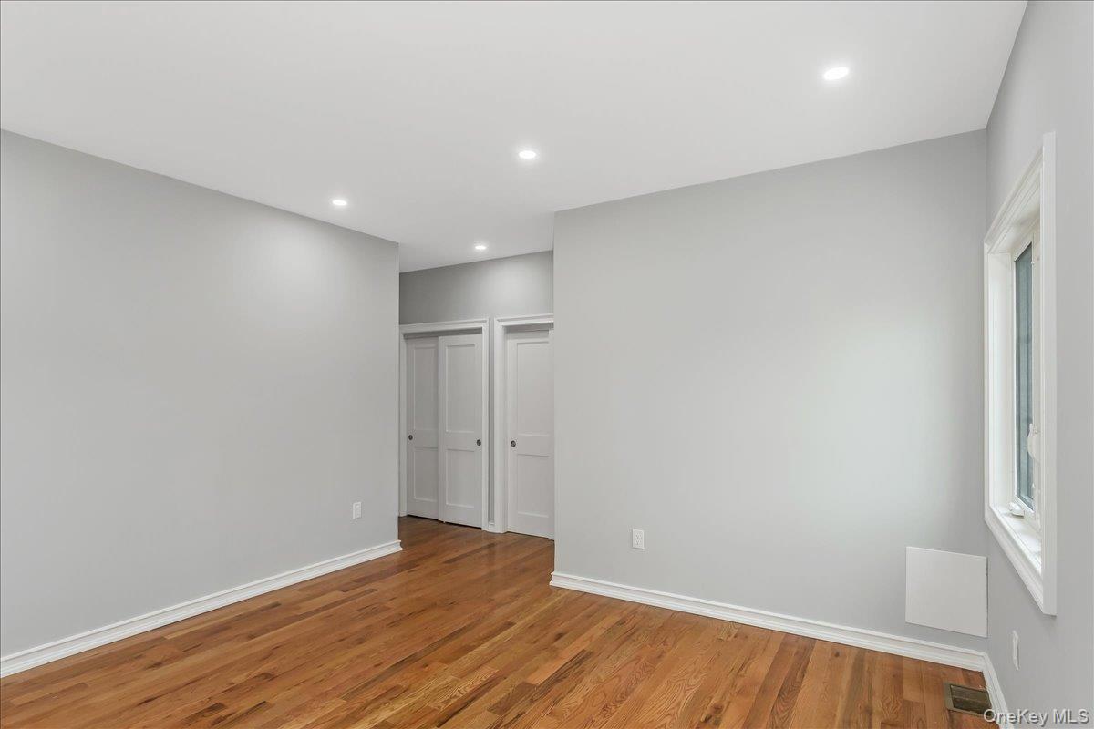 243-36 Caney Road Queens, NY 11422 - Photo 9 of 30 Unfurnished bedroom featuring wood finished floors, recessed lighting, and multiple closets