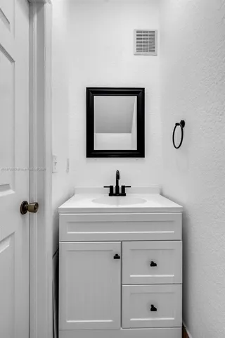 a bathroom with a sink vanity and a mirror