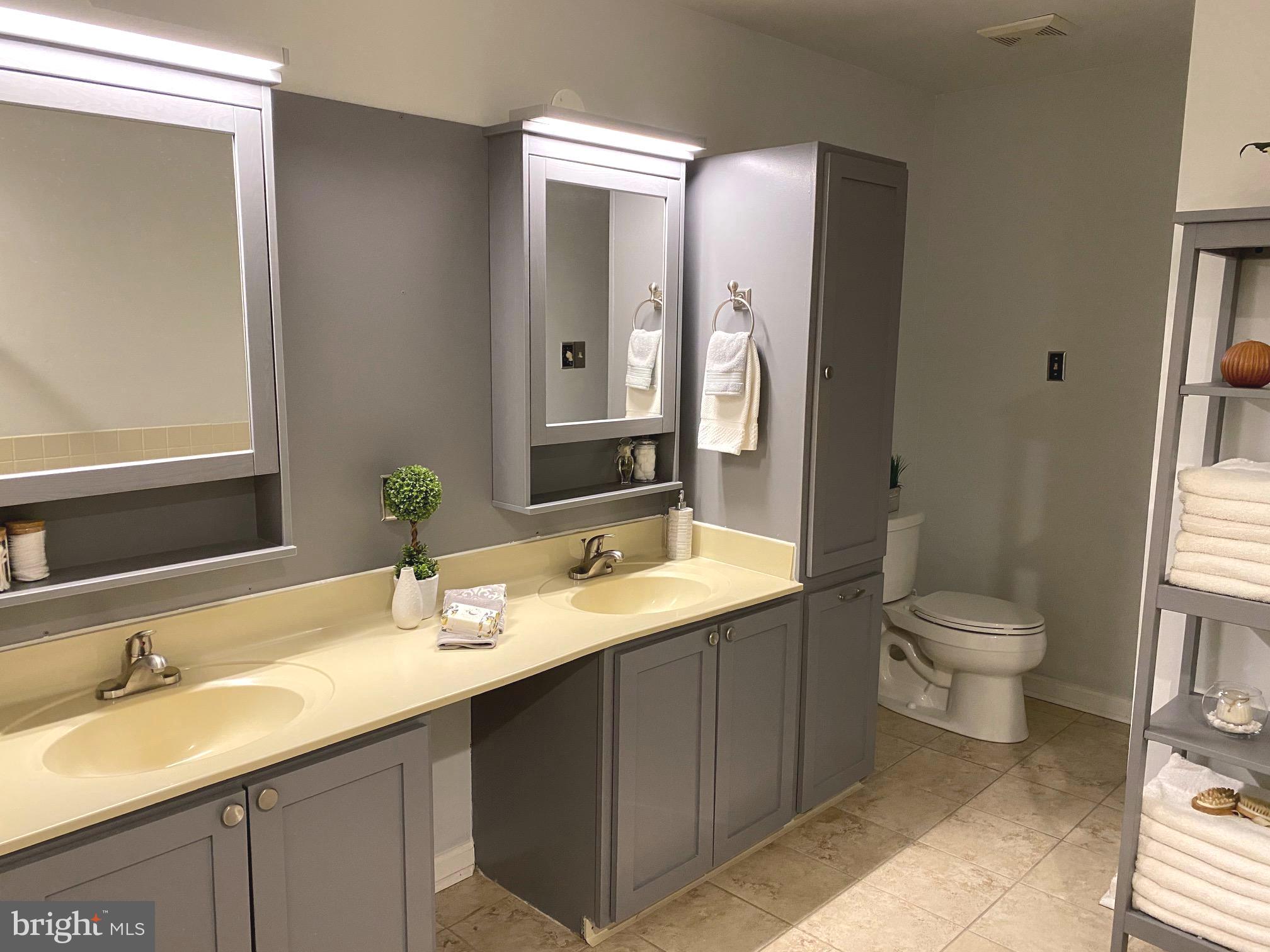 45 Main Street Chesterbrook, PA 19087 - Photo 18 of 36 a bathroom with a granite countertop sink toilet a large mirror and a shower