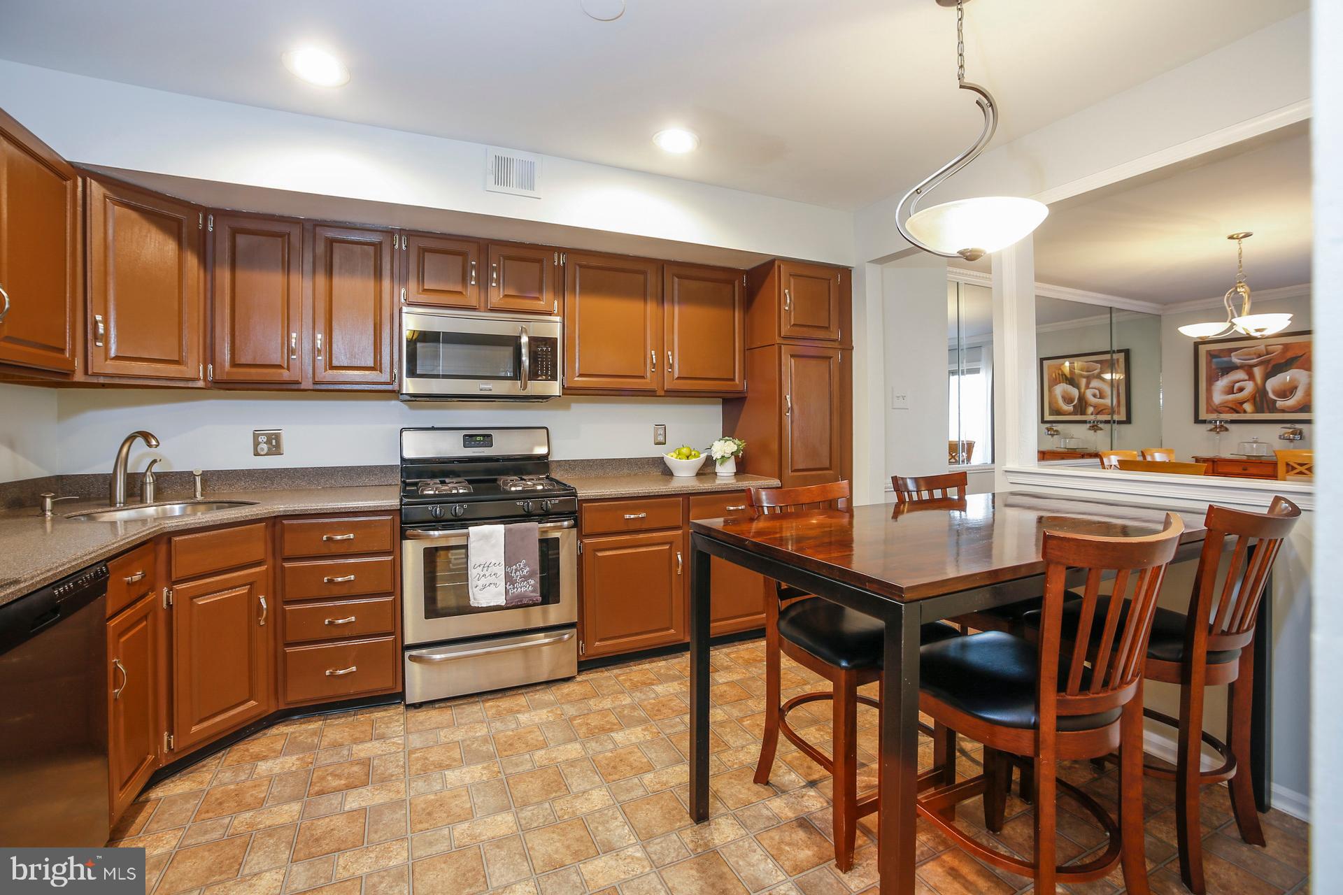 45 Main Street Chesterbrook, PA 19087 - Photo 7 of 36 a kitchen with stainless steel appliances granite countertop wooden cabinets a stove a sink a dining table and chairs