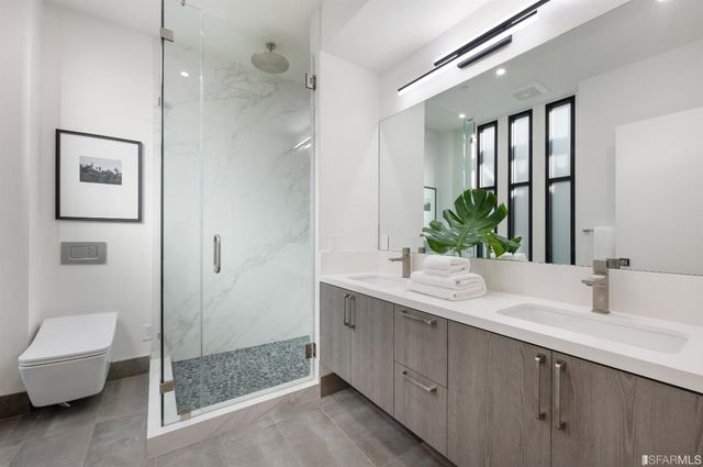 a bathroom with a double vanity sink mirror and toilet