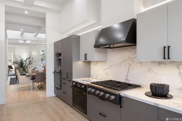 a kitchen with a stove and a flat screen tv