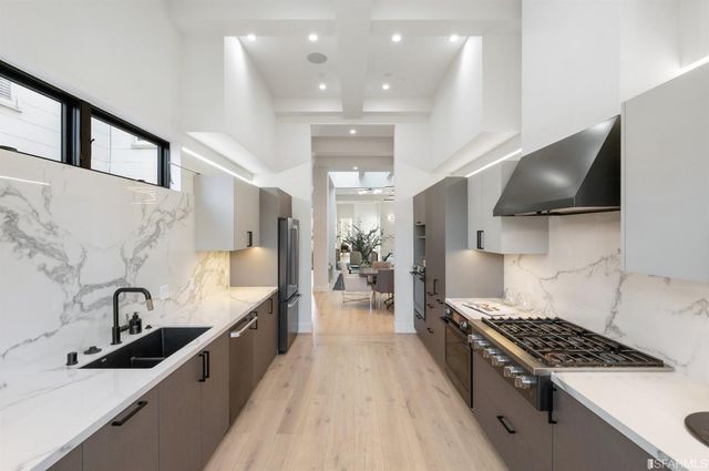 a kitchen with granite countertop a sink stove and cabinets