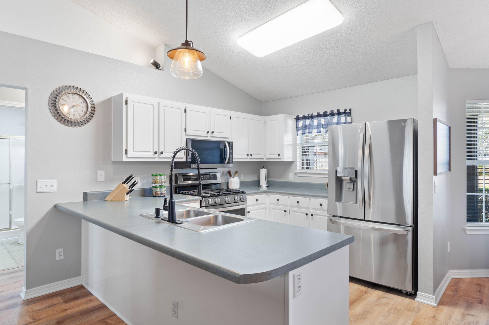 6779 Cedar Ridge Circle Milton, FL 32570 - Photo 13 of 46 a kitchen with stainless steel appliances a sink a stove a refrigerator cabinets and a dining table
