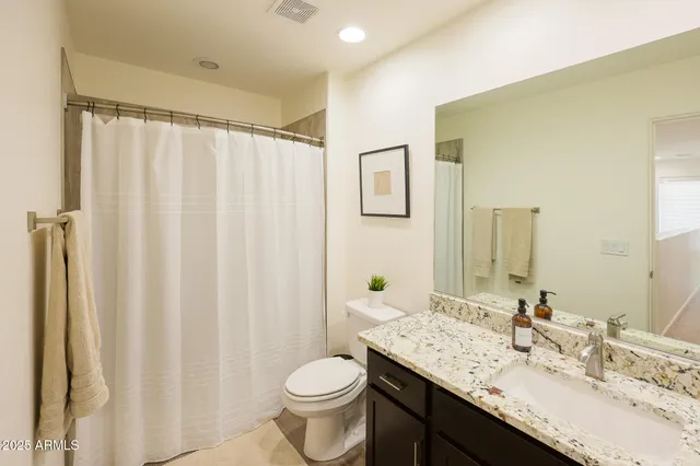 a bathroom with a bathtub shower and toilet