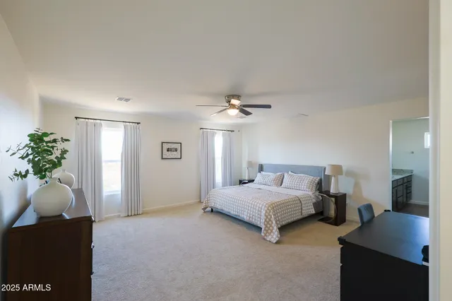 a bedroom with a bed and a ceiling fan