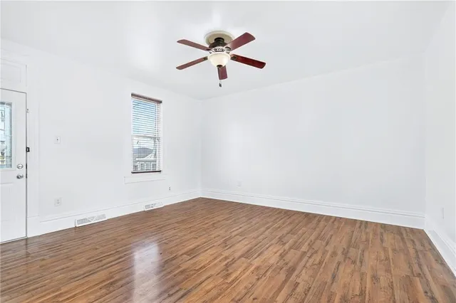 a view of empty room with wooden floor