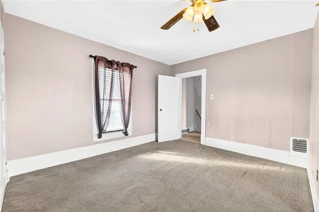 an empty room with windows and cabinet