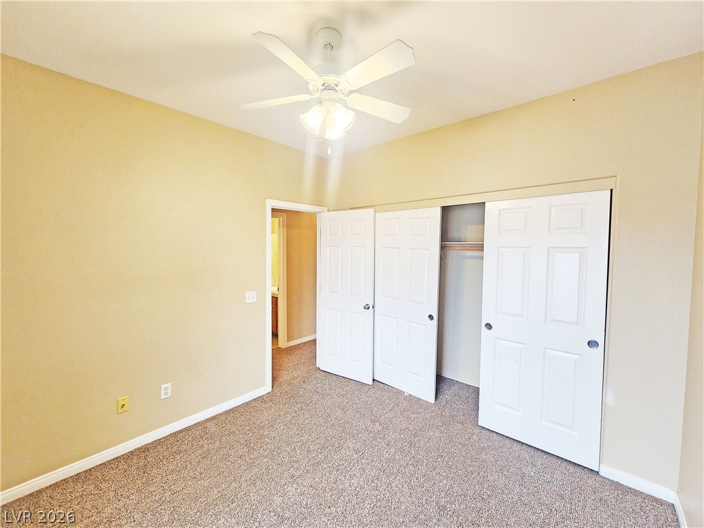 1421 Star Road, Unit 2 Pahrump, NV 89048 - Photo 21 of 33 Unfurnished bedroom with a ceiling fan, baseboards, carpet, and a closet