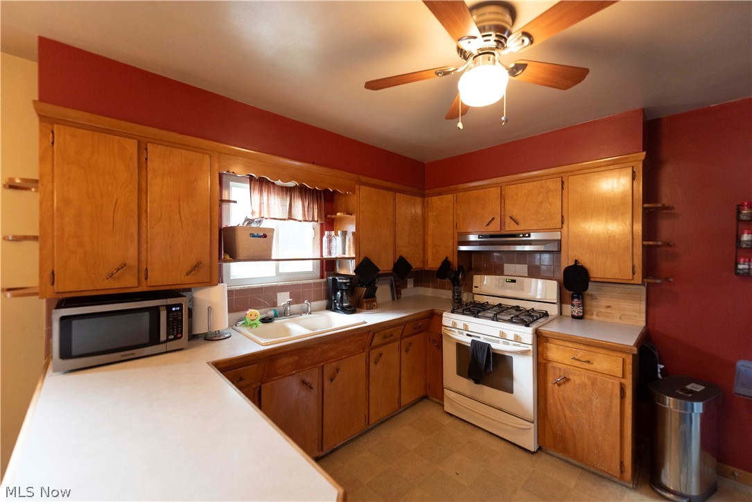 400 Baldwin Road Akron, OH 44312 - Photo 9 of 43 Kitchen featuring wood cabinetry, white countertops, a built-in oven with a gas range, a dual-basin sink, and a ceiling fan with integrated lighting