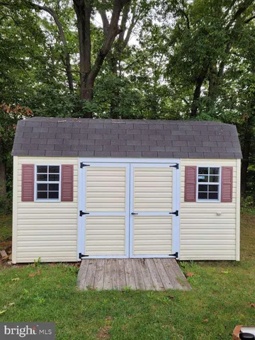 a view of a backyard with plants and a small cabin