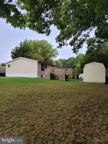 a view of a house with a yard and a tree