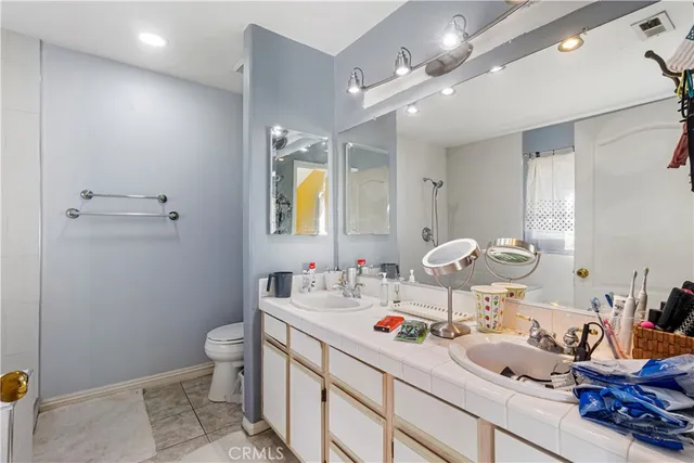 a bathroom with a granite countertop sink a toilet and a mirror