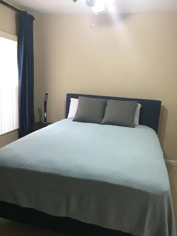 a bed sitting in a bedroom next to a window