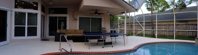 a view of a patio with table and chairs with wooden floor and fence