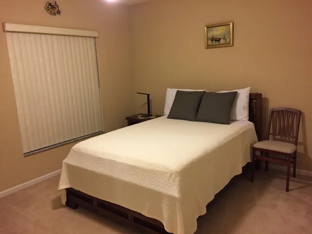 a large bed sitting in a bedroom next to a window