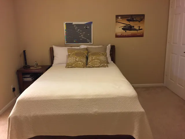 a large bed sitting in a bedroom and chair