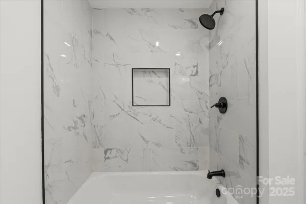 a bathroom with a bathtub and shower
