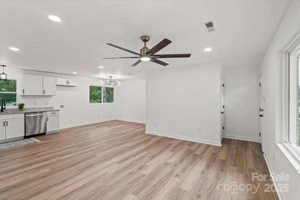 an empty room with wooden floor and a ceiling fan