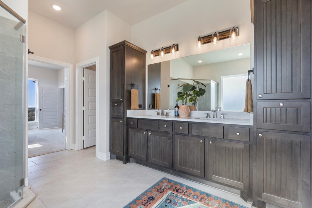 517 Dancing Sun Road Fredericksburg, TX 78624 - Photo 29 of 37 a spacious bathroom with a sink a mirror and a shower