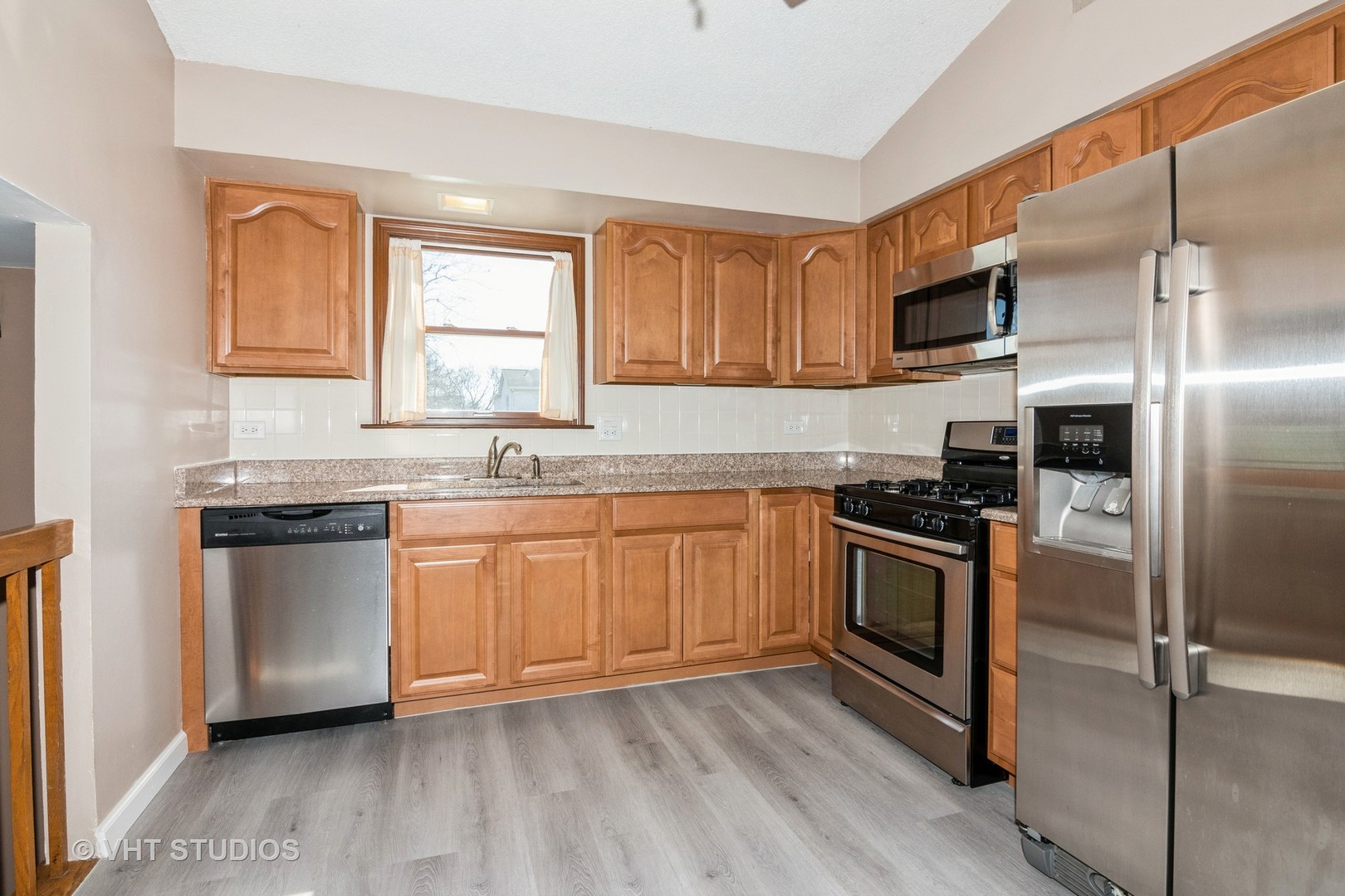 1295 Chatsworth Lane Hoffman Estates, IL 60169 - Photo 7 of 24 a kitchen with stainless steel appliances granite countertop a stove a sink and a refrigerator