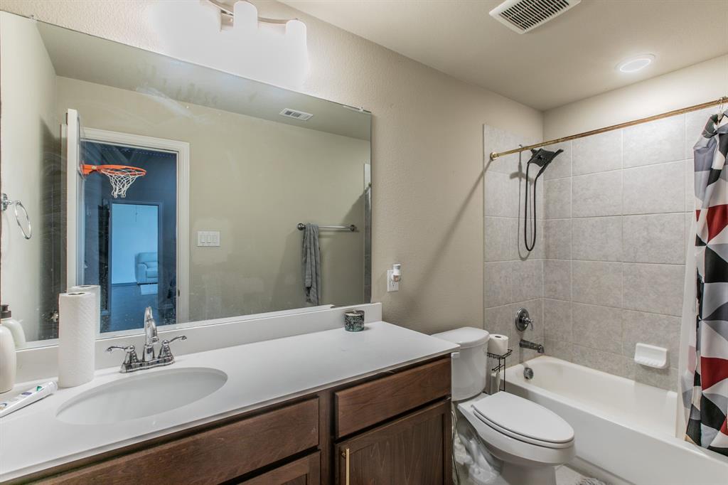 2521 Maidenhair Road Frisco, TX 75033 - Photo 25 of 39 Bathroom featuring a single vanity with wood-finish cabinetry, a white countertop, and an undermount sink