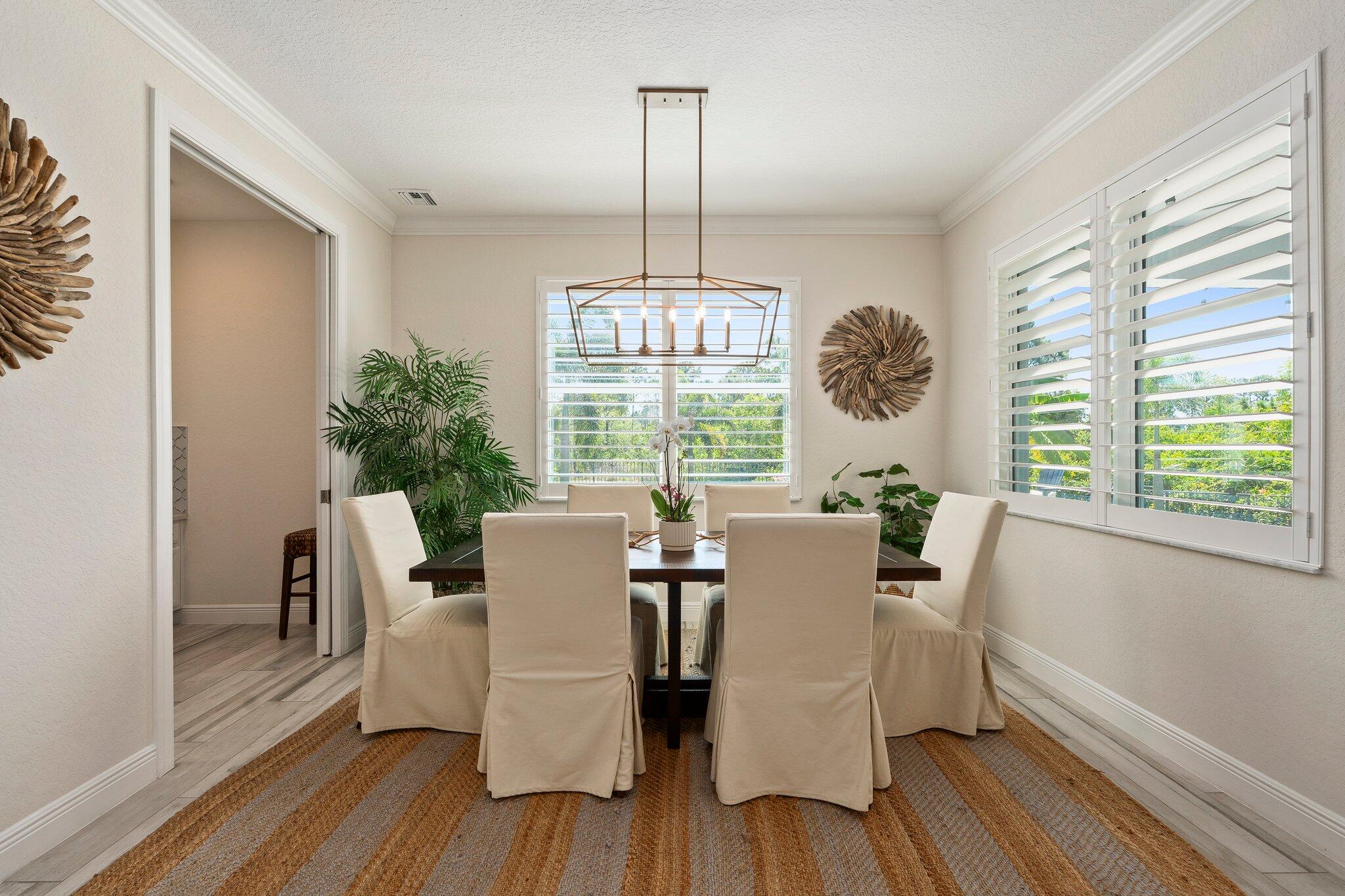 4701 Southwest Ardsley Drive Stuart, FL 34997 - Photo 16 of 83 a dining room with furniture a chandelier and wooden floor