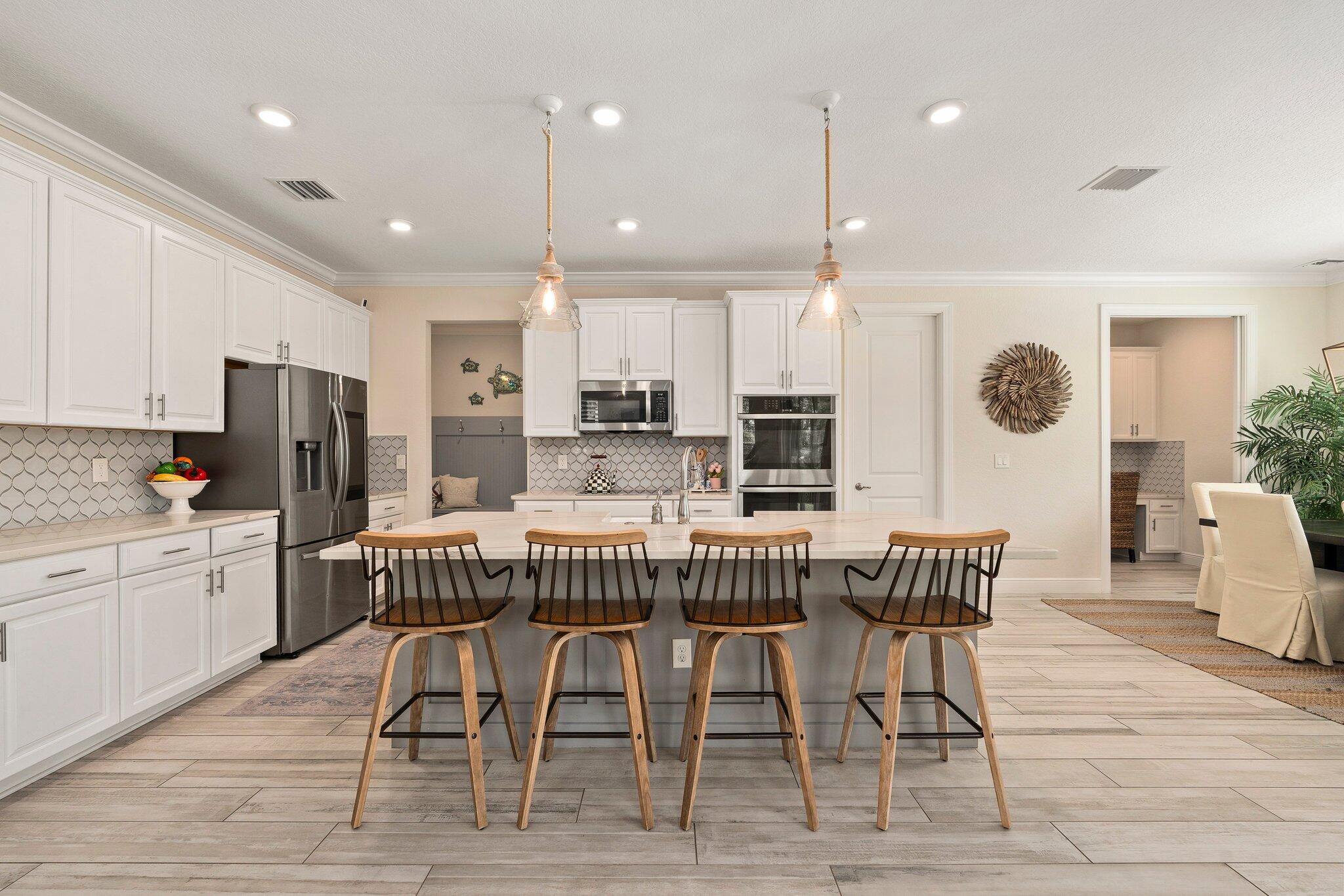 4701 Southwest Ardsley Drive Stuart, FL 34997 - Photo 19 of 83 a kitchen with stainless steel appliances kitchen island granite countertop a dining table chairs and sink