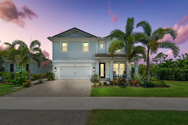 a front view of a house with a yard and potted plants