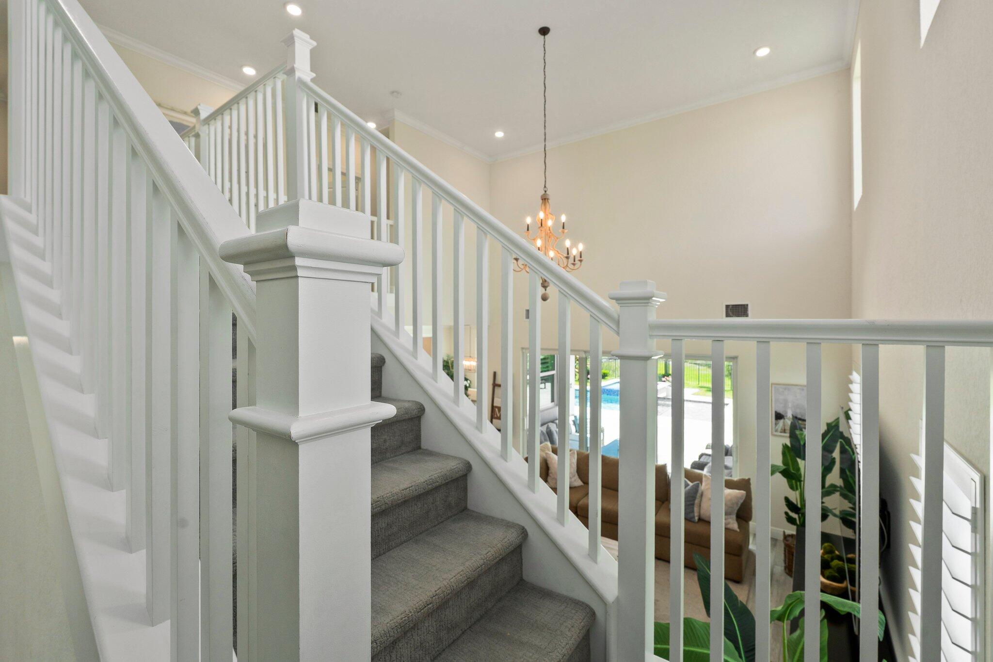 4701 Southwest Ardsley Drive Stuart, FL 34997 - Photo 26 of 83 a view of staircase with lots of frames on wall and windows