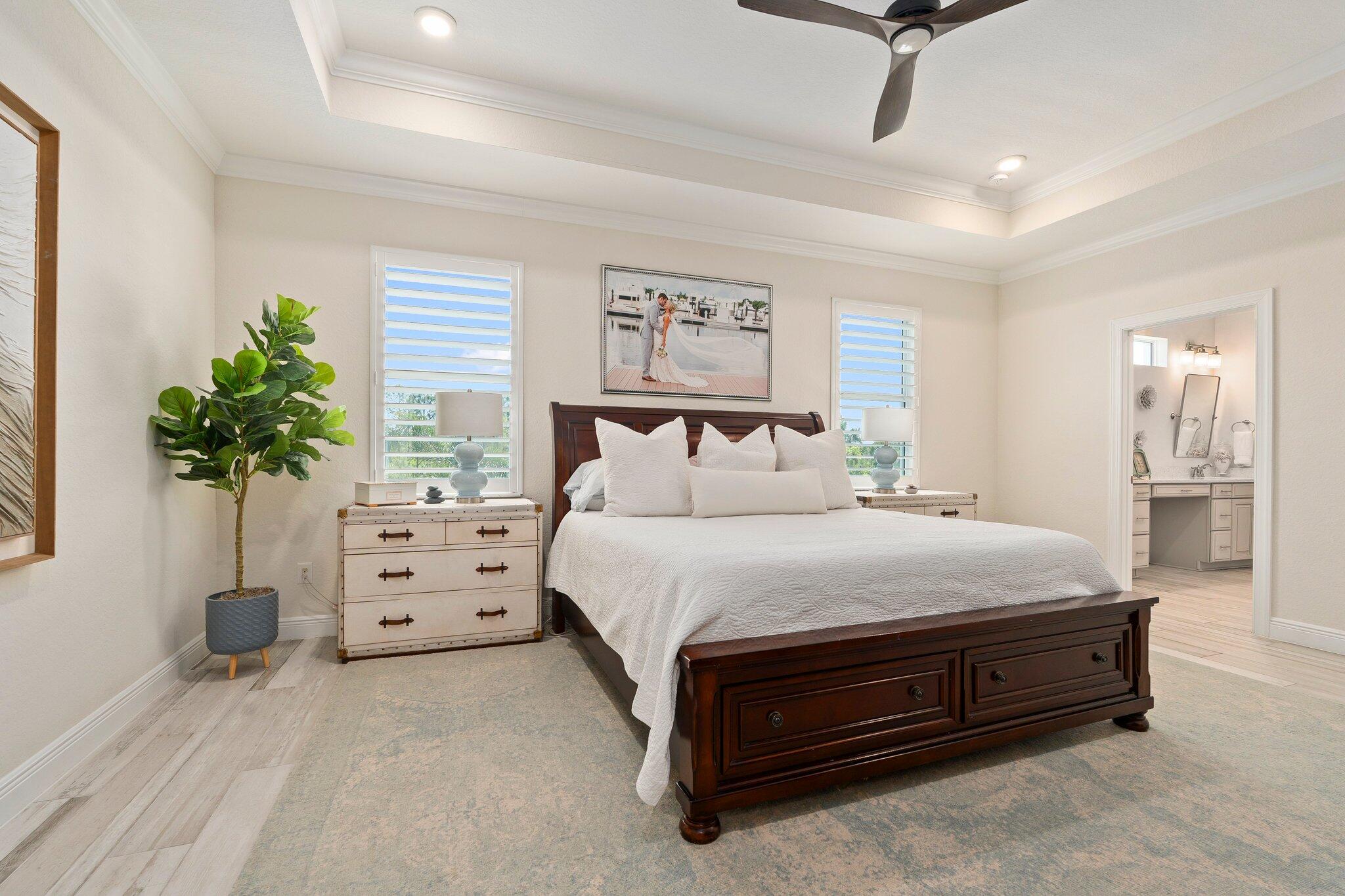 4701 Southwest Ardsley Drive Stuart, FL 34997 - Photo 32 of 83 a spacious bedroom with a bed and a potted plant