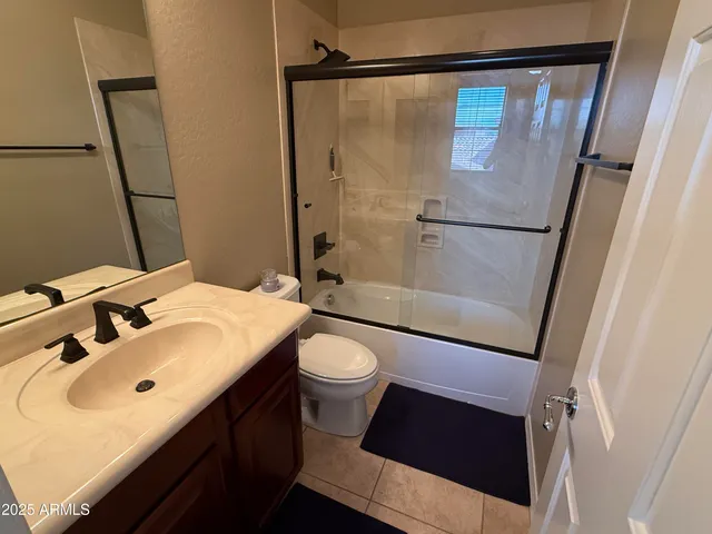 a bathroom with a sink a toilet a mirror and shower