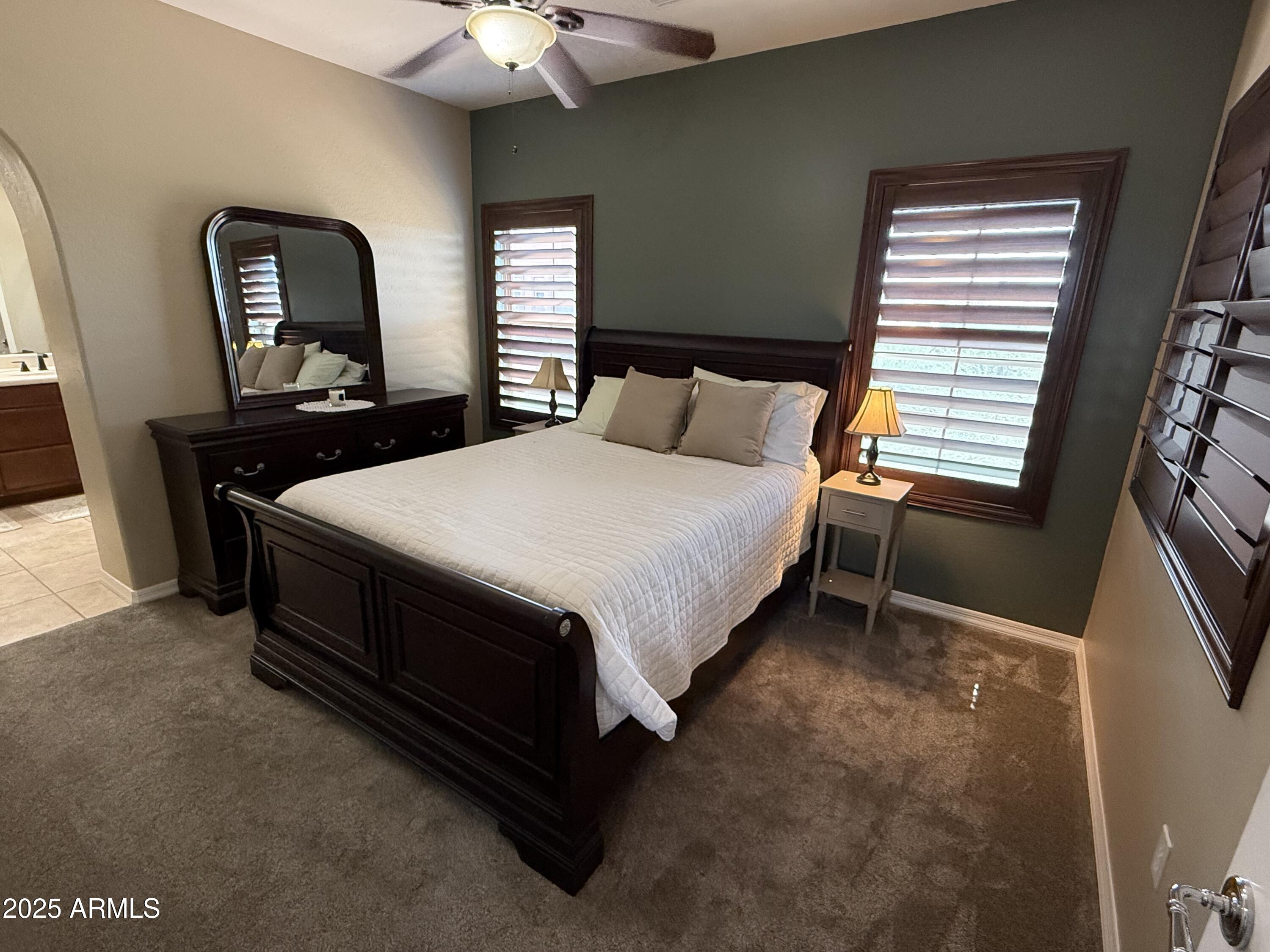3935 East Rough Rider Road, Unit 1014 Phoenix, AZ 85050 - Photo 15 of 40 a bed sitting in a bedroom next to a window