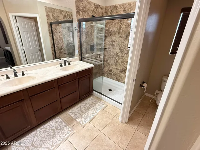 a bathroom with a double vanity sink toilet and mirror