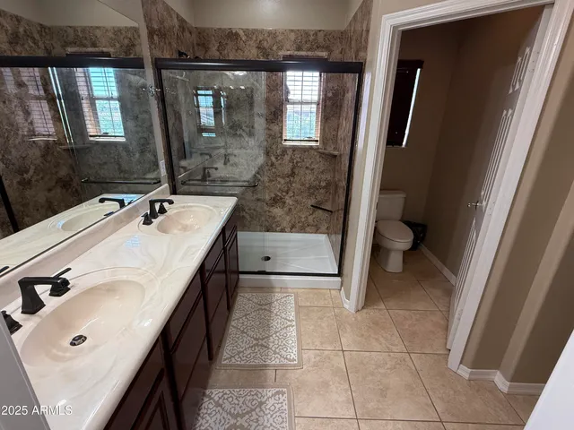 a spacious bathroom with a sink a toilet and mirror