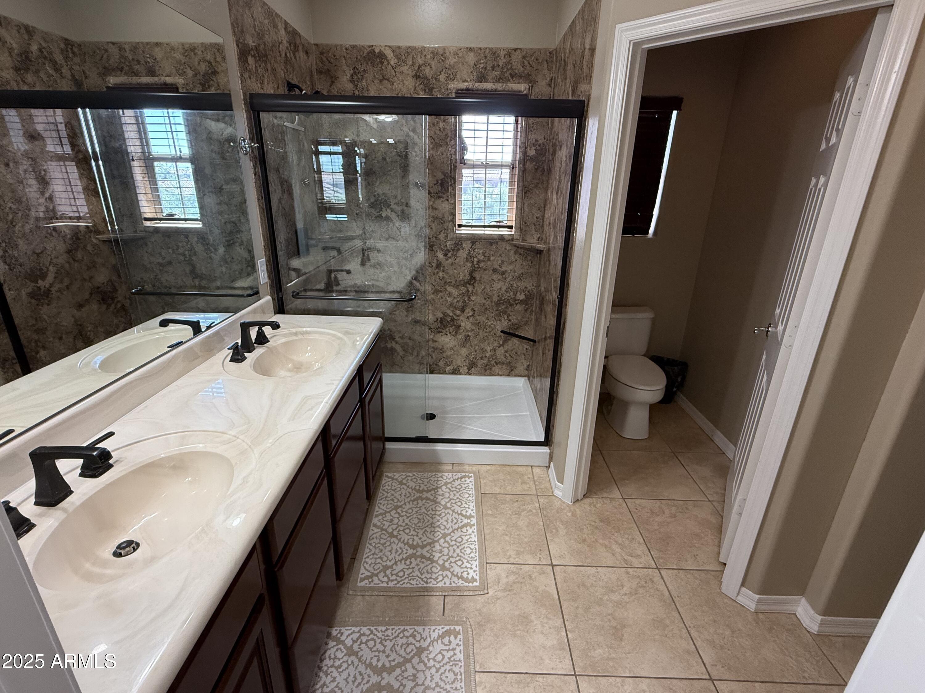 3935 East Rough Rider Road, Unit 1014 Phoenix, AZ 85050 - Photo 18 of 40 a spacious bathroom with a sink a toilet and mirror
