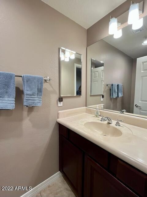 3935 East Rough Rider Road, Unit 1014 Phoenix, AZ 85050 - Photo 22 of 40 a bathroom with a sink a mirror and a vanity