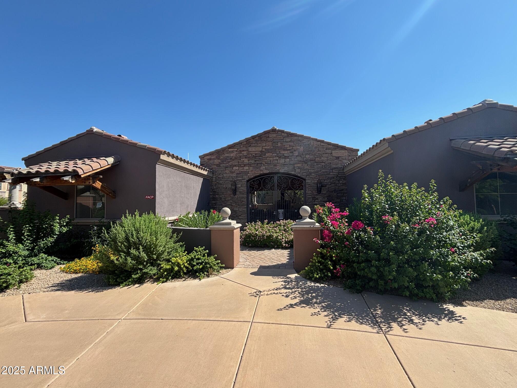 3935 East Rough Rider Road, Unit 1014 Phoenix, AZ 85050 - Photo 25 of 40 a front view of house with a garden