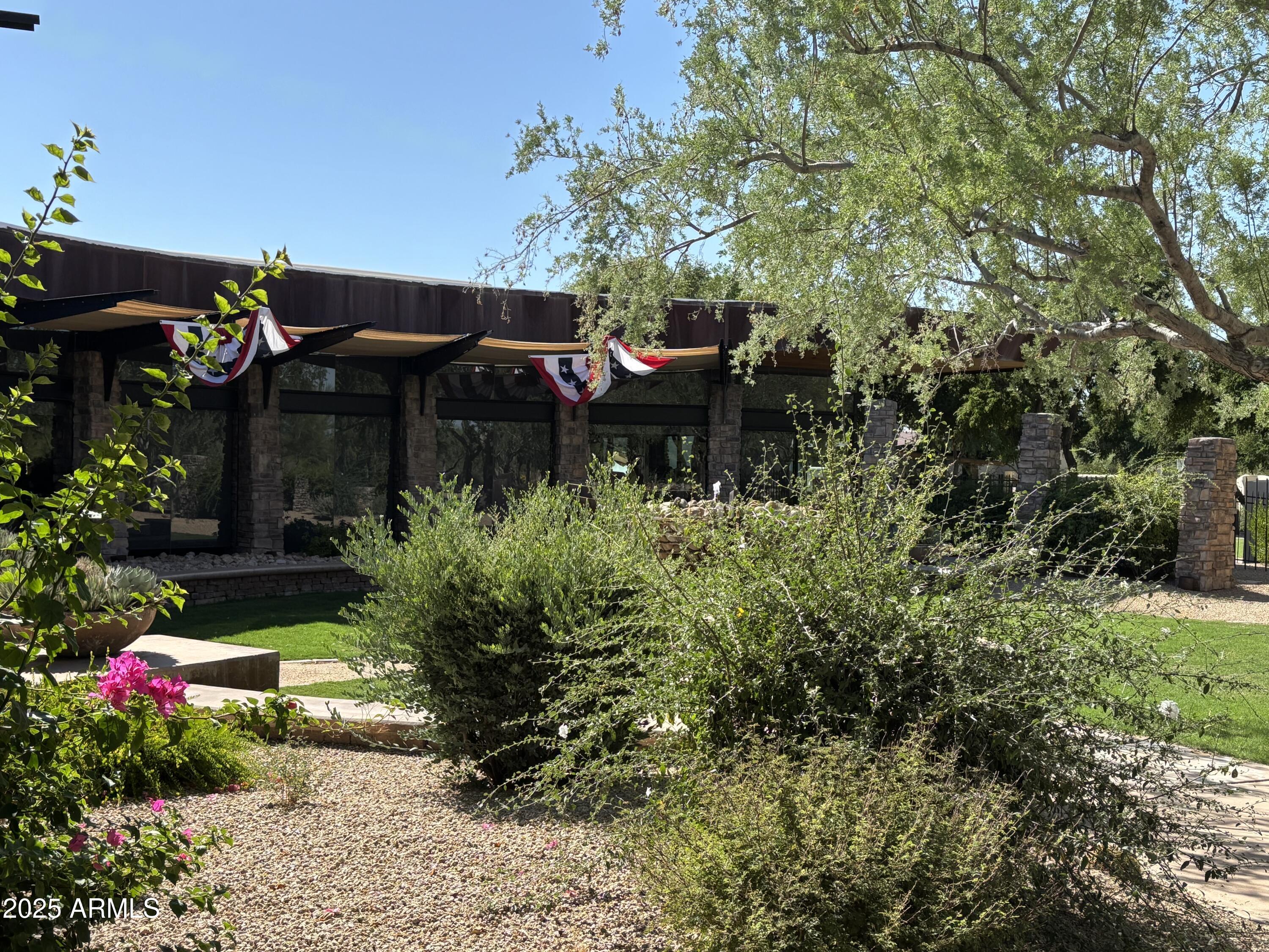 3935 East Rough Rider Road, Unit 1014 Phoenix, AZ 85050 - Photo 27 of 40 a backyard of a house with lots of green space and trees