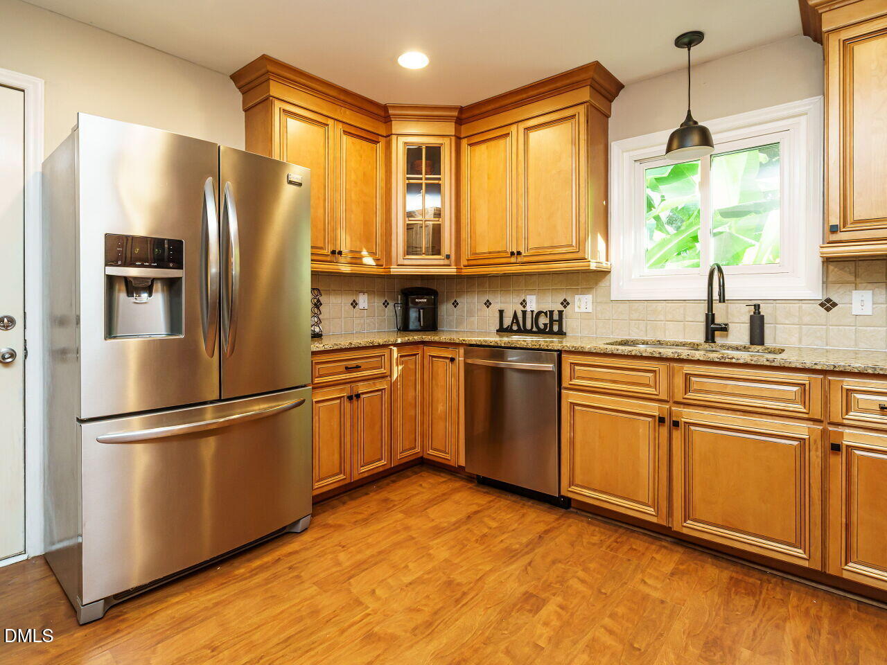 4104 Betterton Drive Raleigh, NC 27613 - Photo 12 of 32 a kitchen with stainless steel appliances granite countertop a refrigerator sink and wooden cabinets