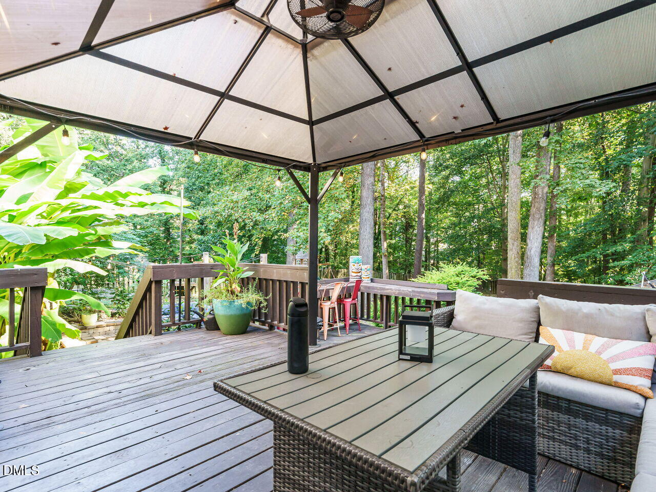 4104 Betterton Drive Raleigh, NC 27613 - Photo 23 of 32 a view of a patio with couches table and chairs under an umbrella