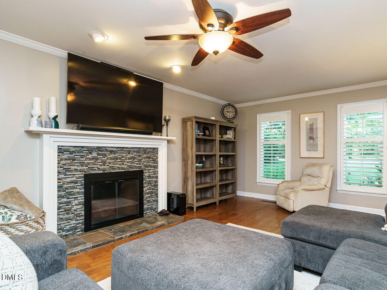 4104 Betterton Drive Raleigh, NC 27613 - Photo 6 of 32 a living room with furniture a flat screen tv and a fireplace