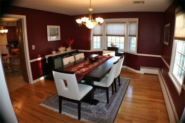 a dining room with wooden floor and chandelier