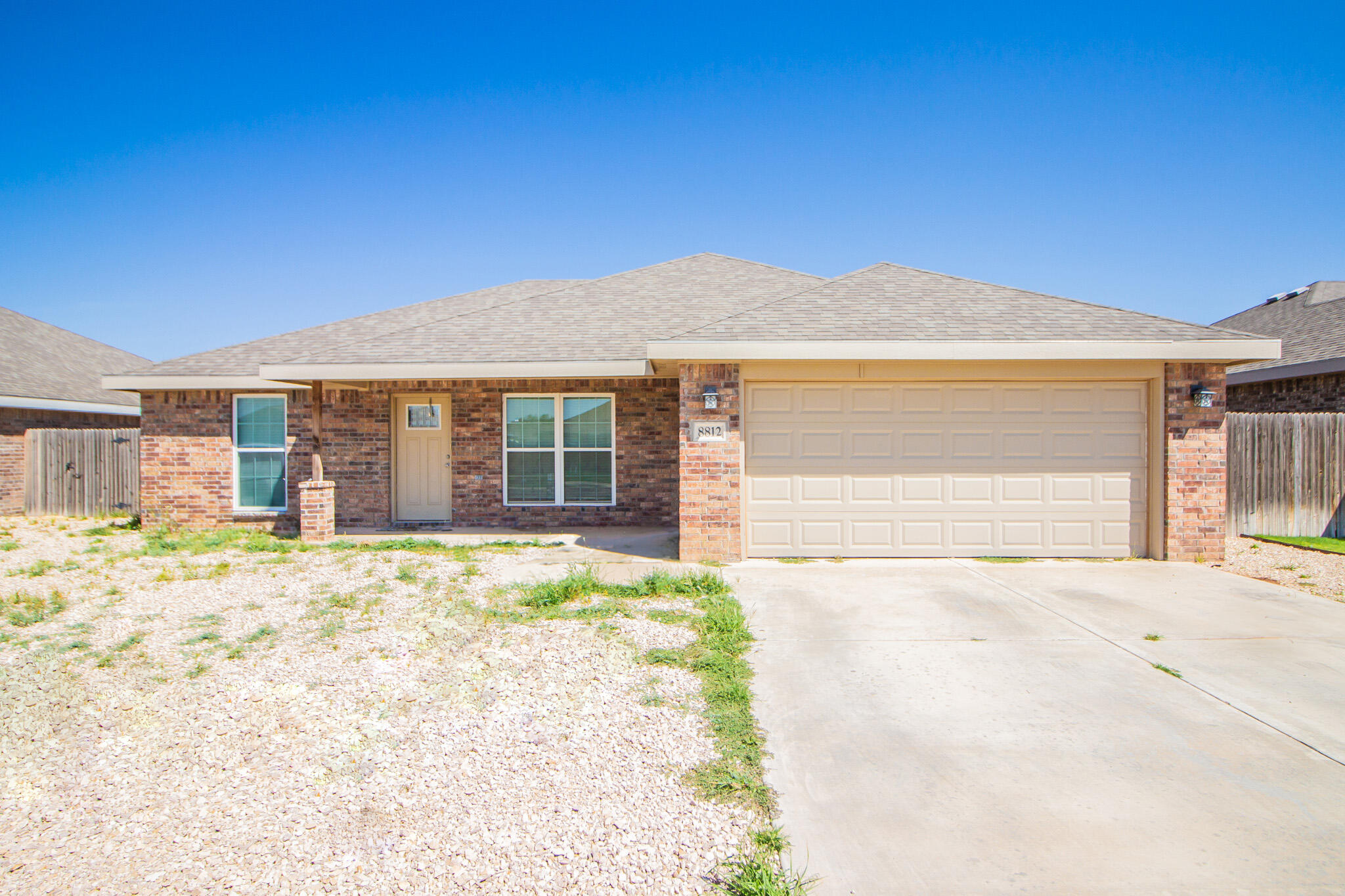 8812 15th Street Lubbock, TX 79416 - Photo 1 of 16 a front view of a house with a yard and garage