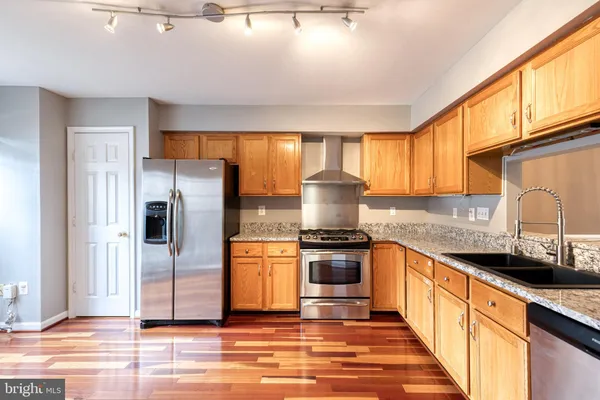 a kitchen with stainless steel appliances granite countertop a sink stove and refrigerator