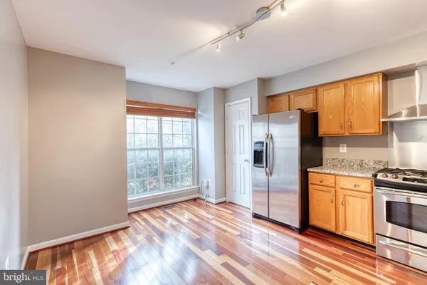 a kitchen with stainless steel appliances granite countertop a refrigerator and a stove top oven