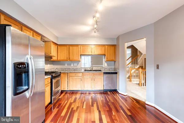 a kitchen with stainless steel appliances granite countertop a refrigerator and a stove top oven